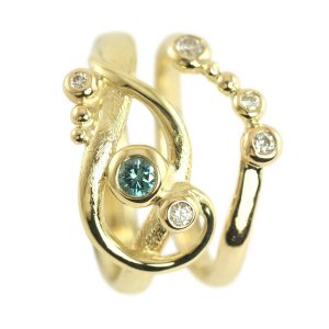 Twisted gold engagement ring with large blue diamond and small white diamonds