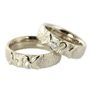 White gold wedding rings with zodiac sign, rough surface and diamond