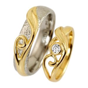 Unique white gold and gold wedding rings with scrolls and large white diamond