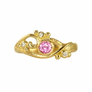 Beautiful gold ring with large pink sapphire and two small white diamonds
